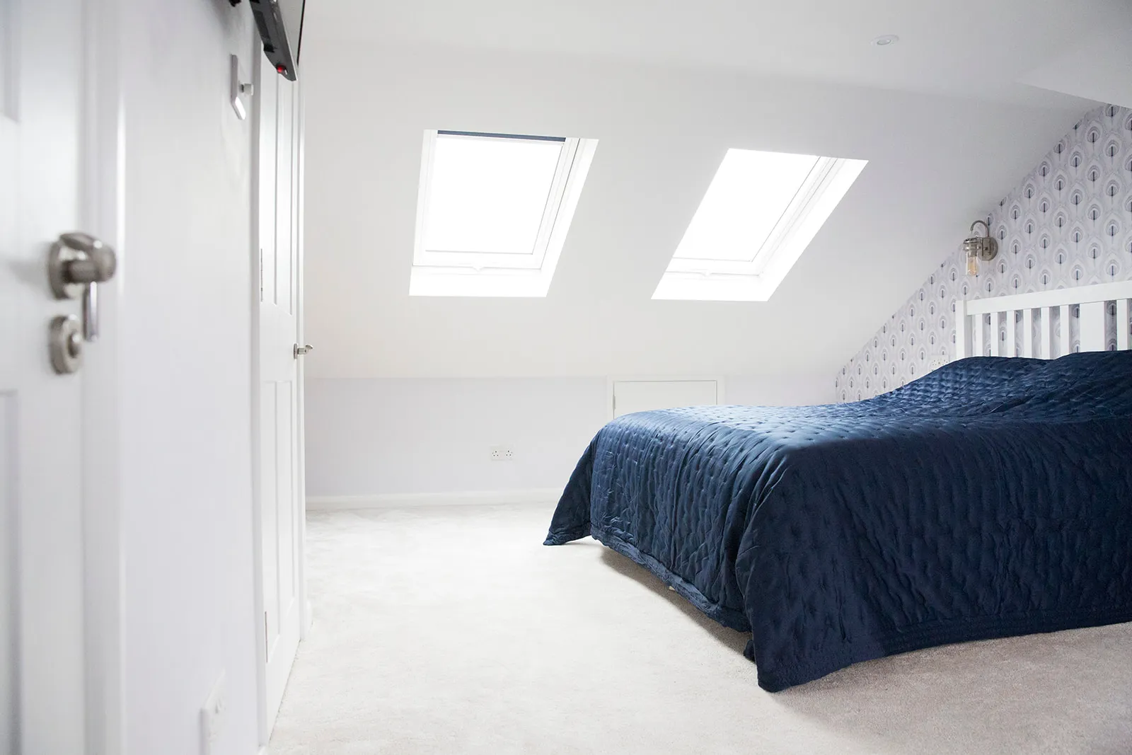 A bedroom with a bed and a skylight.